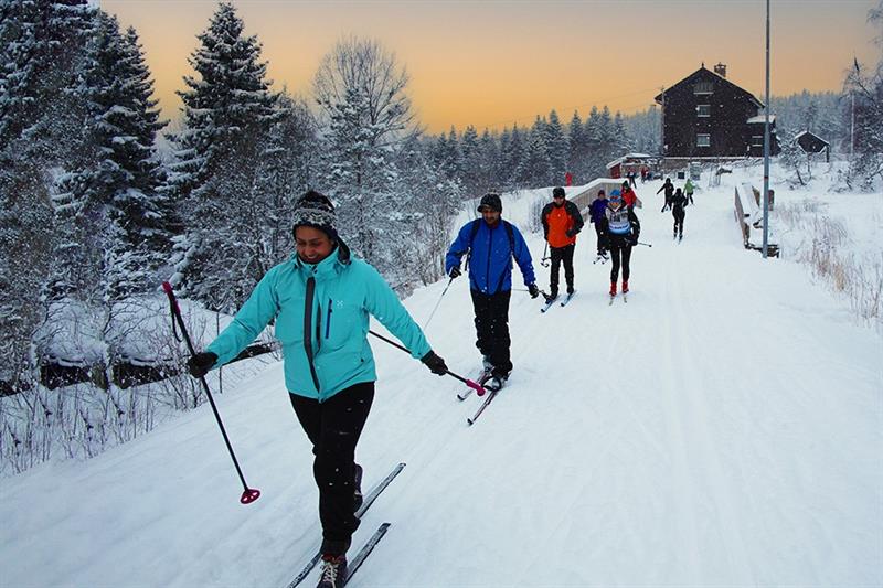 A group of cross-country skiers in a line on the ski trail