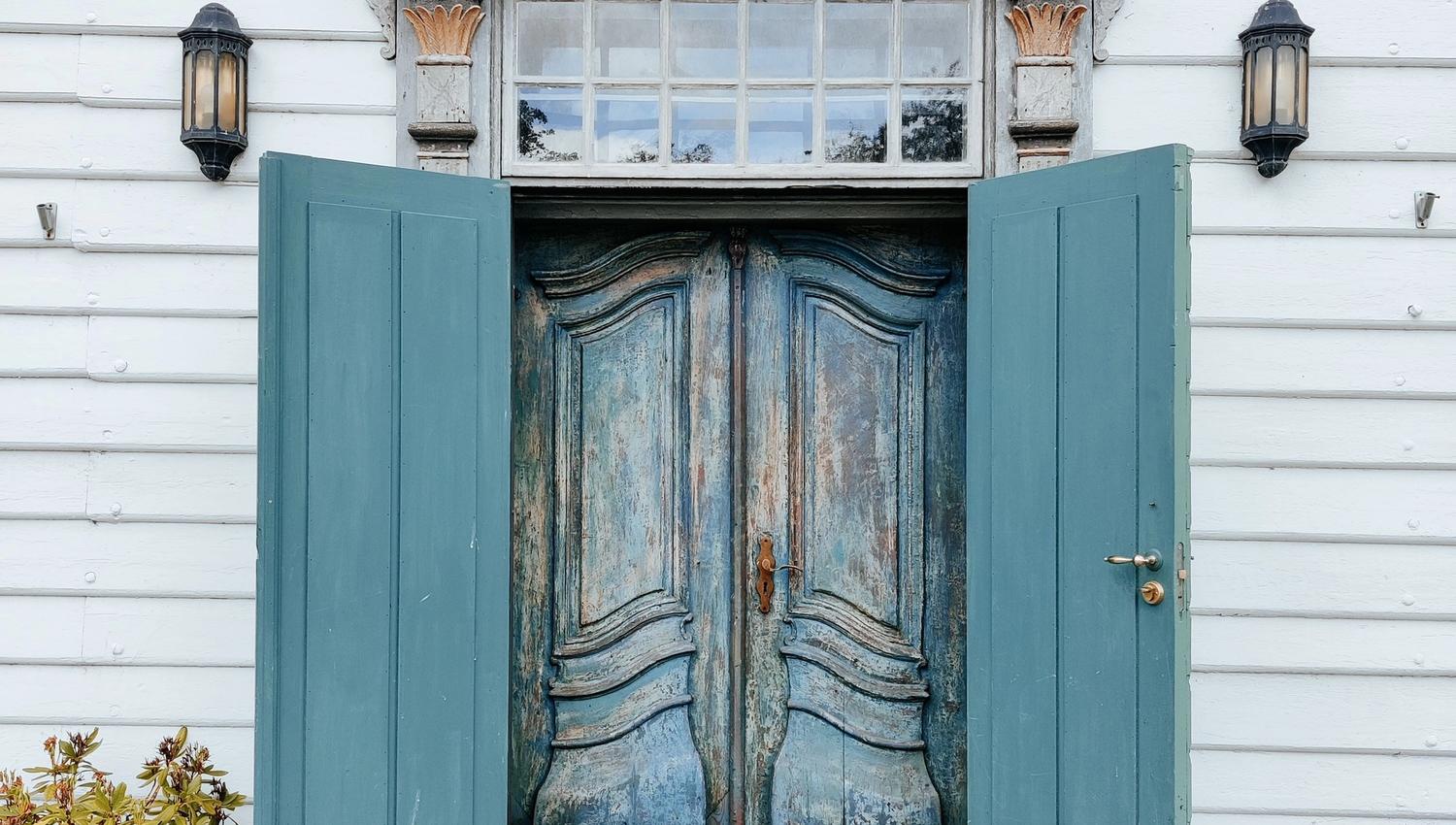 The distinctive entrance to Skrivergaarden with its blue door and historic architectural details.
