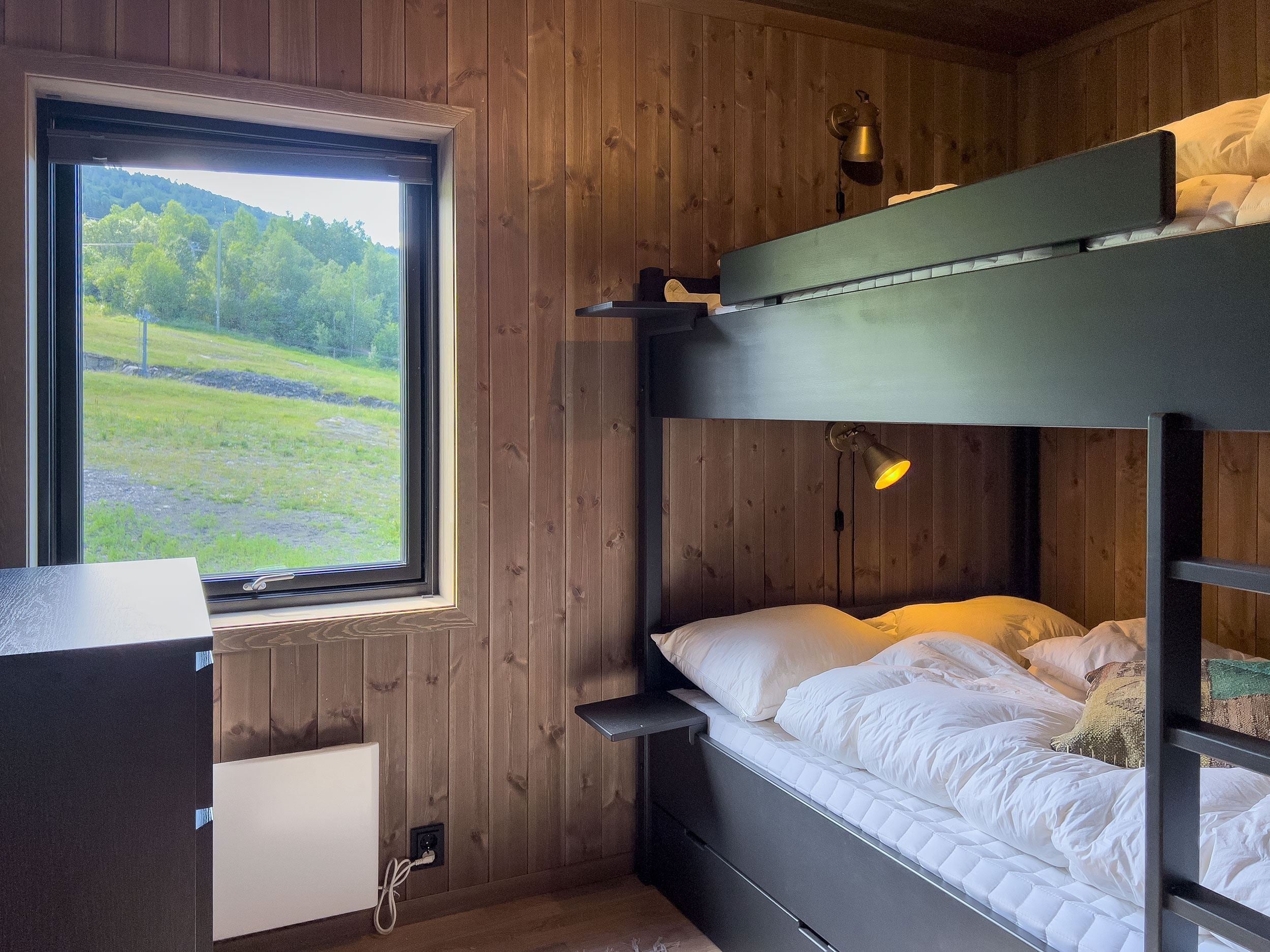 Ein Etagenbett in einem Zimmer mit Fenster und Gras.