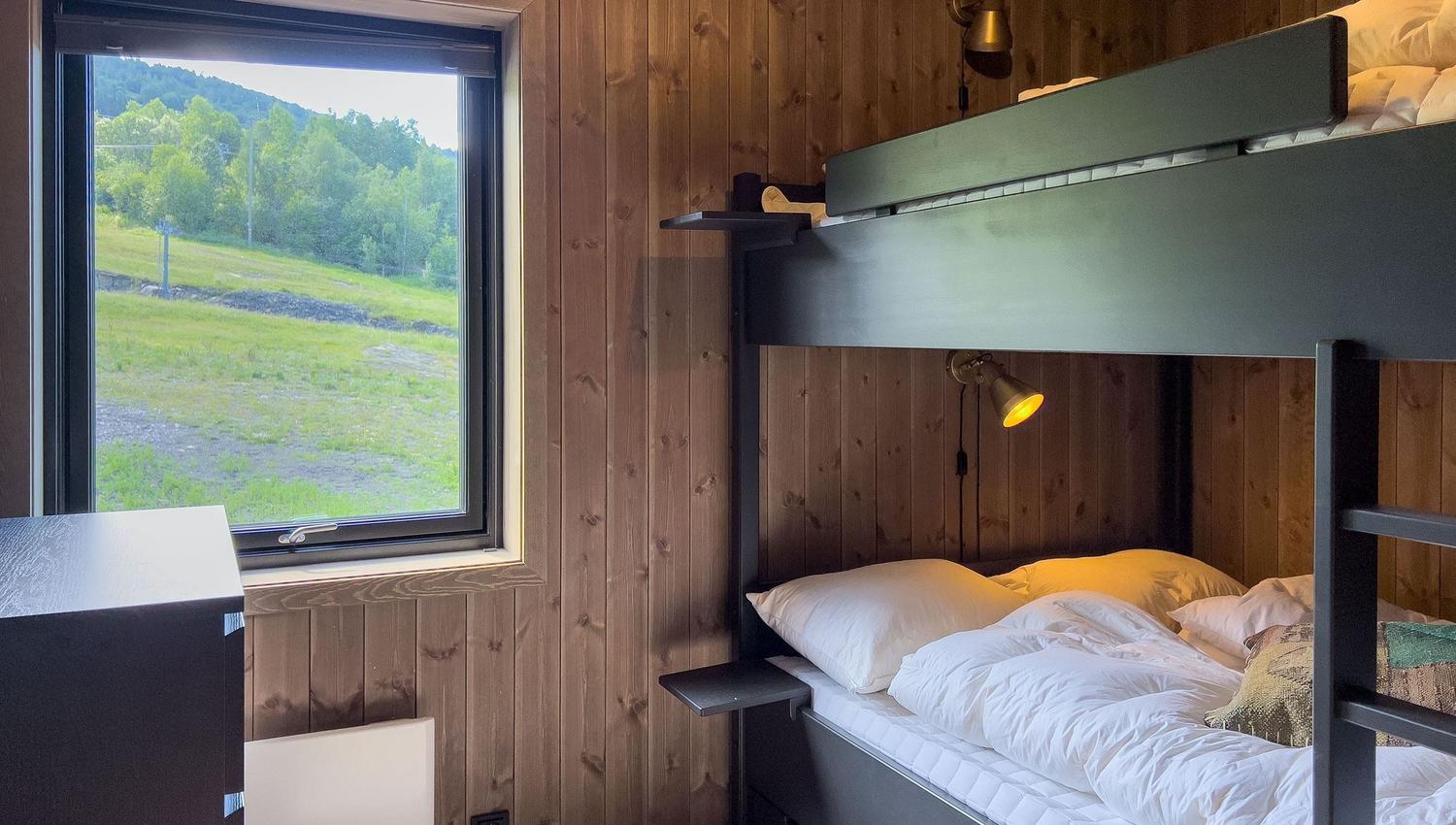 Ein Etagenbett in einem Zimmer mit Fenster und Gras.