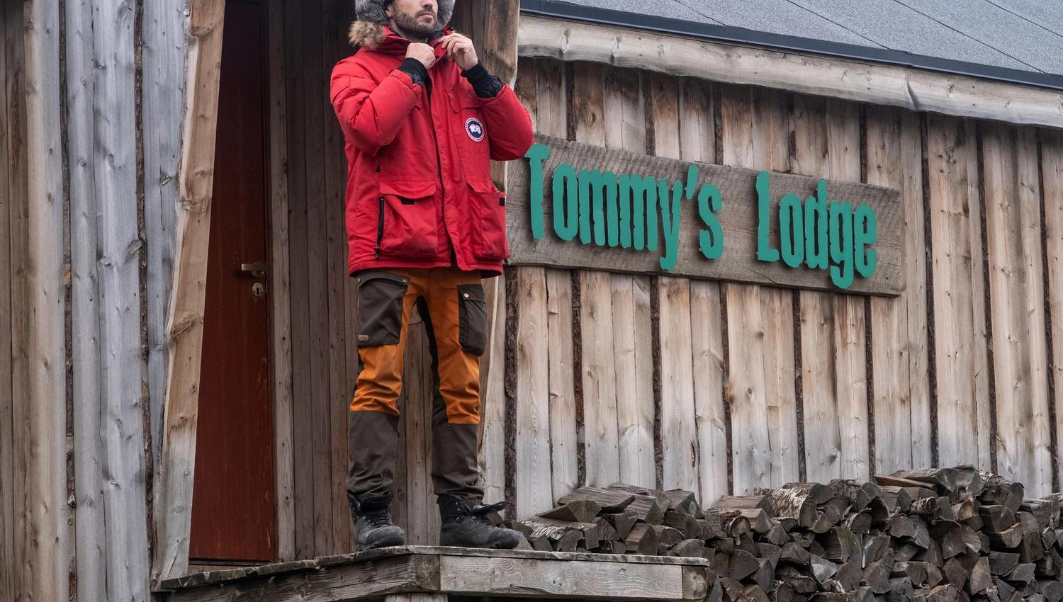 A person standing on some stairs in front of Tommy's Lodge