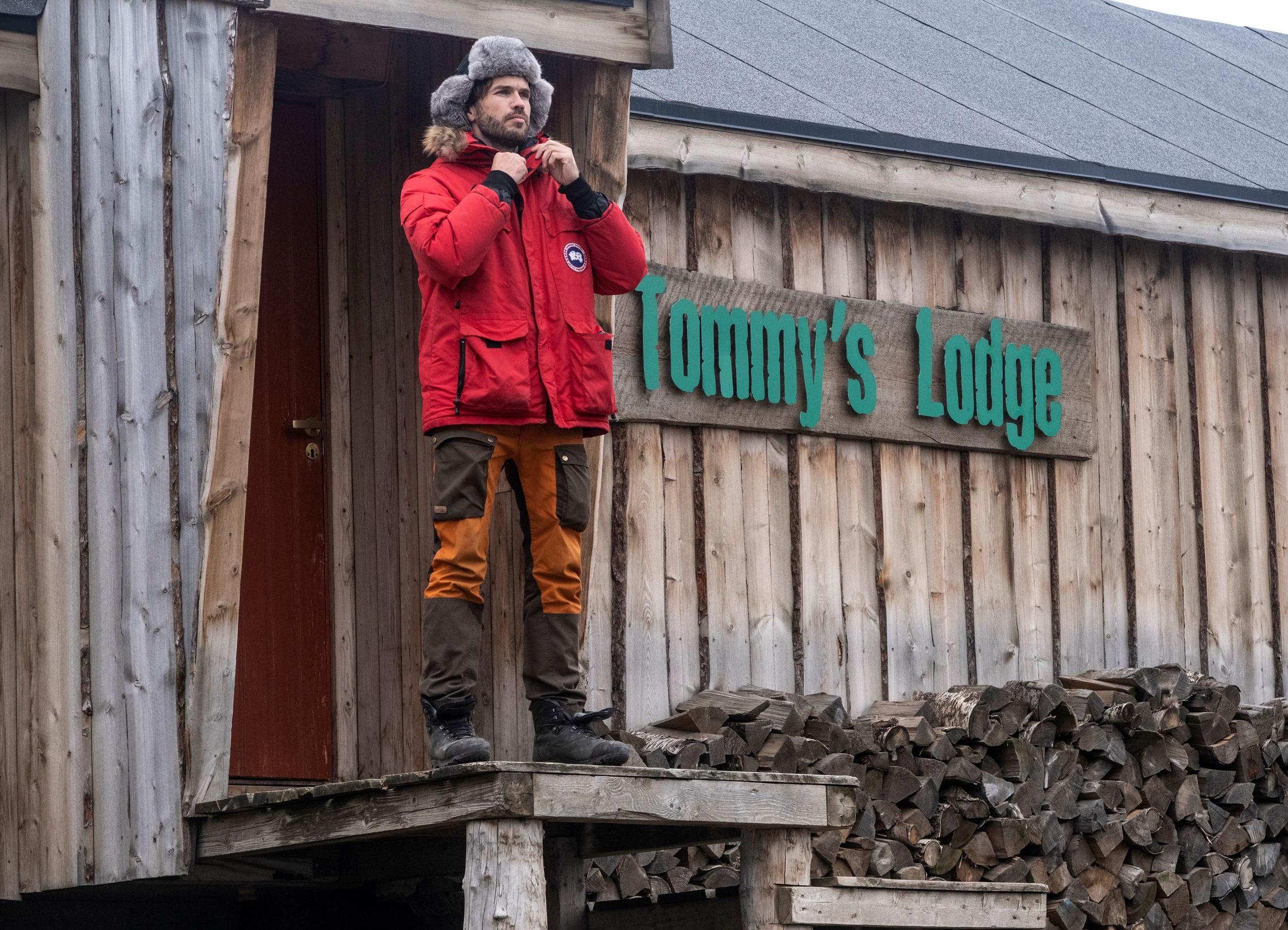En person som står på en trapp foran Tommy's Lodge