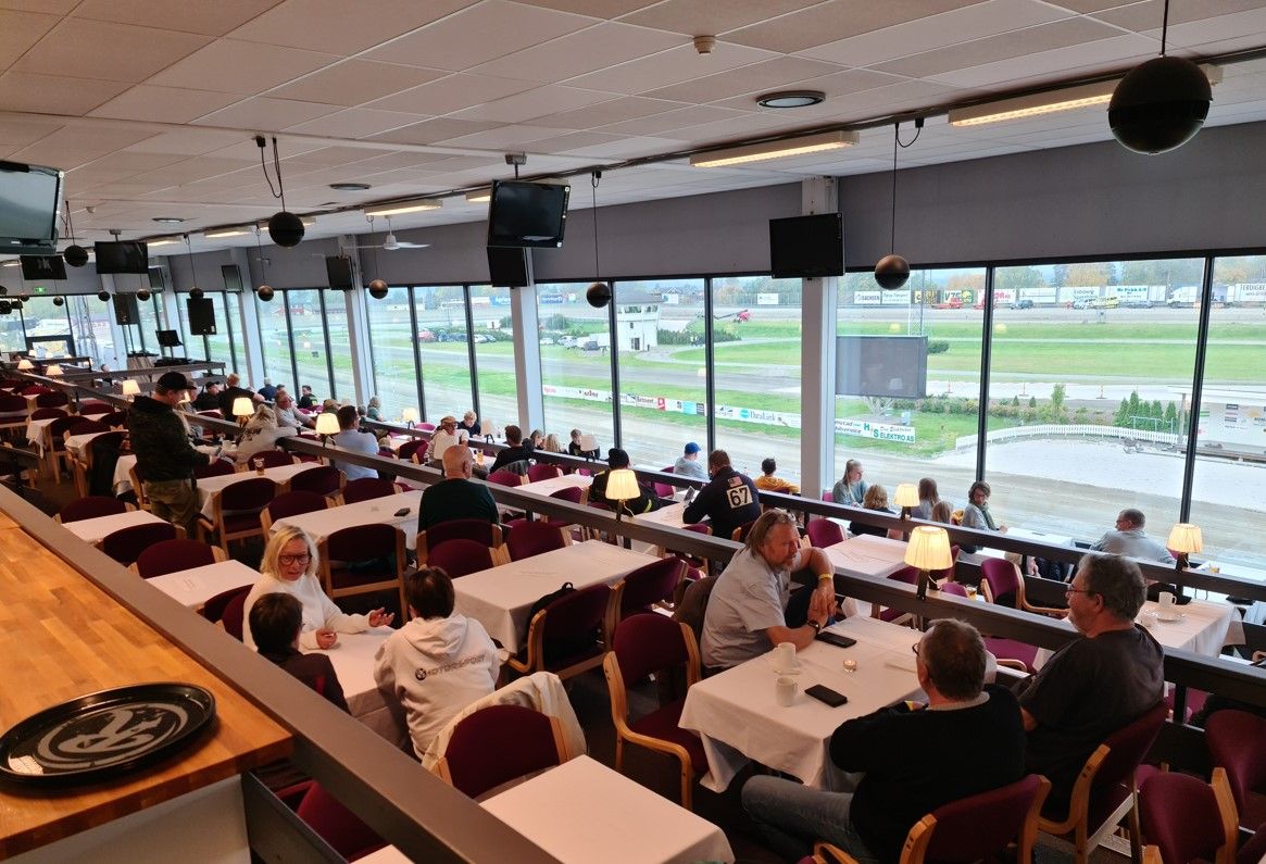 Utsikt utover restauranten, folk ser på travløp