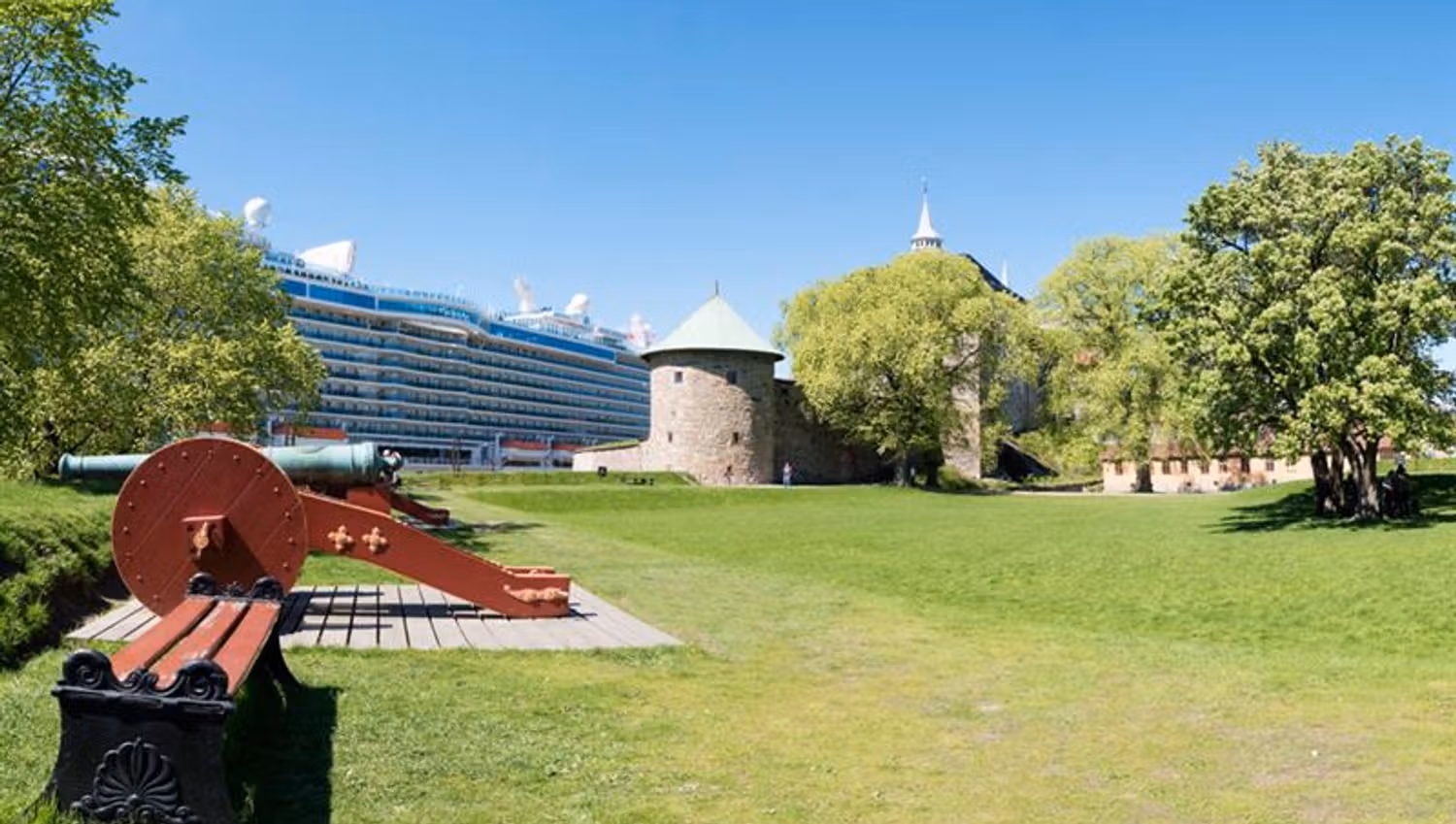 Bench, cannon, grass, trees, Munk's Tower and a cruise ship.