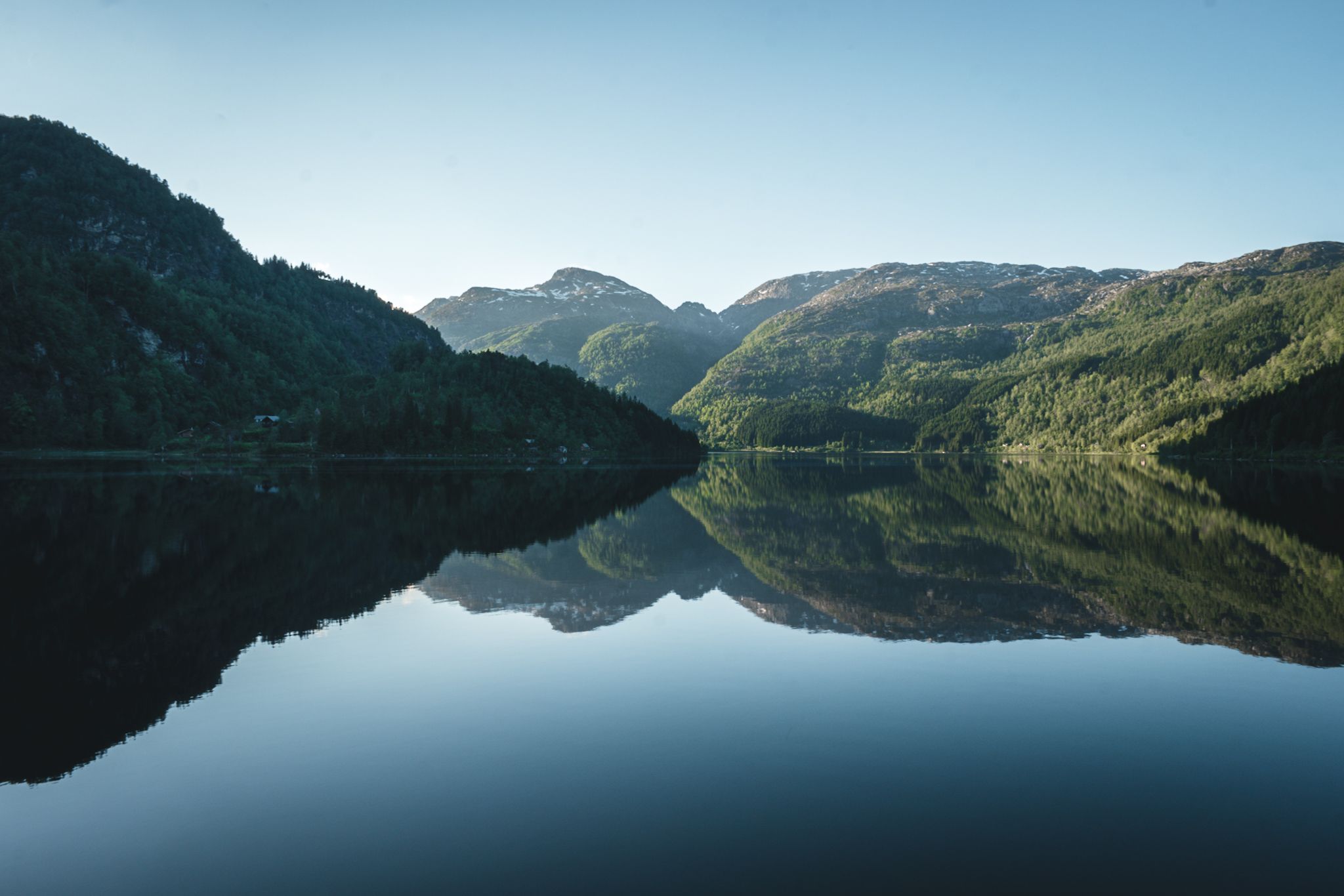 Mirror-calm lake reflecting the surrounding mountains in Hardanger.