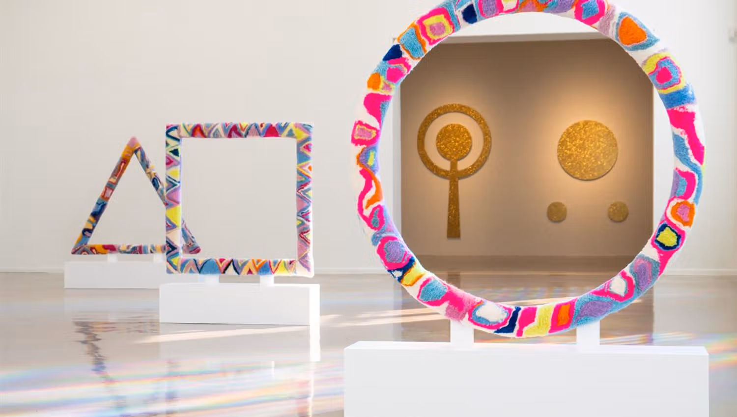 Colorful art installation with geometric shapes in a gallery.