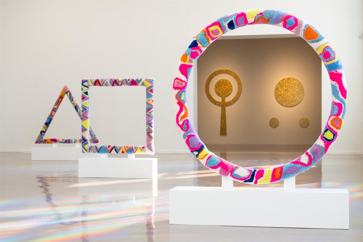 Colorful art installation with geometric shapes in a gallery.
