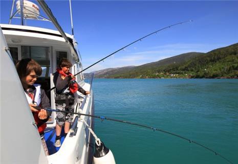 Two children fishing from Pilagutt in the Hardangerfjord – a perfect family activity in stunning nature.