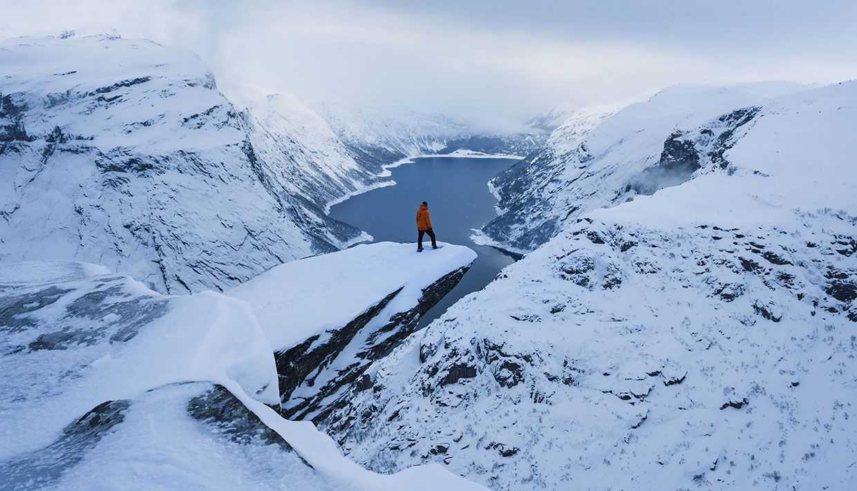 Snowshoe hikers walking in soft evening light on the plateau near Trolltunga.