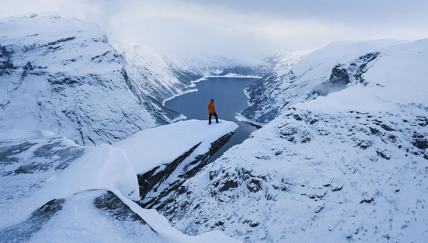 Snowshoe hikers walking in soft evening light on the plateau near Trolltunga.