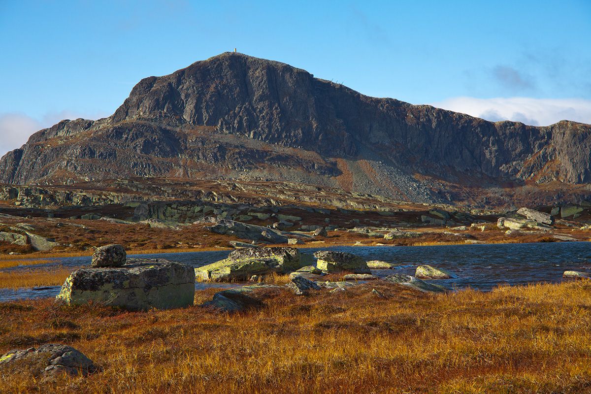 Bitihorn shows its rough side with its steep east face to the photogapher. In the foreground some small lakes and lichen-covered rocks.