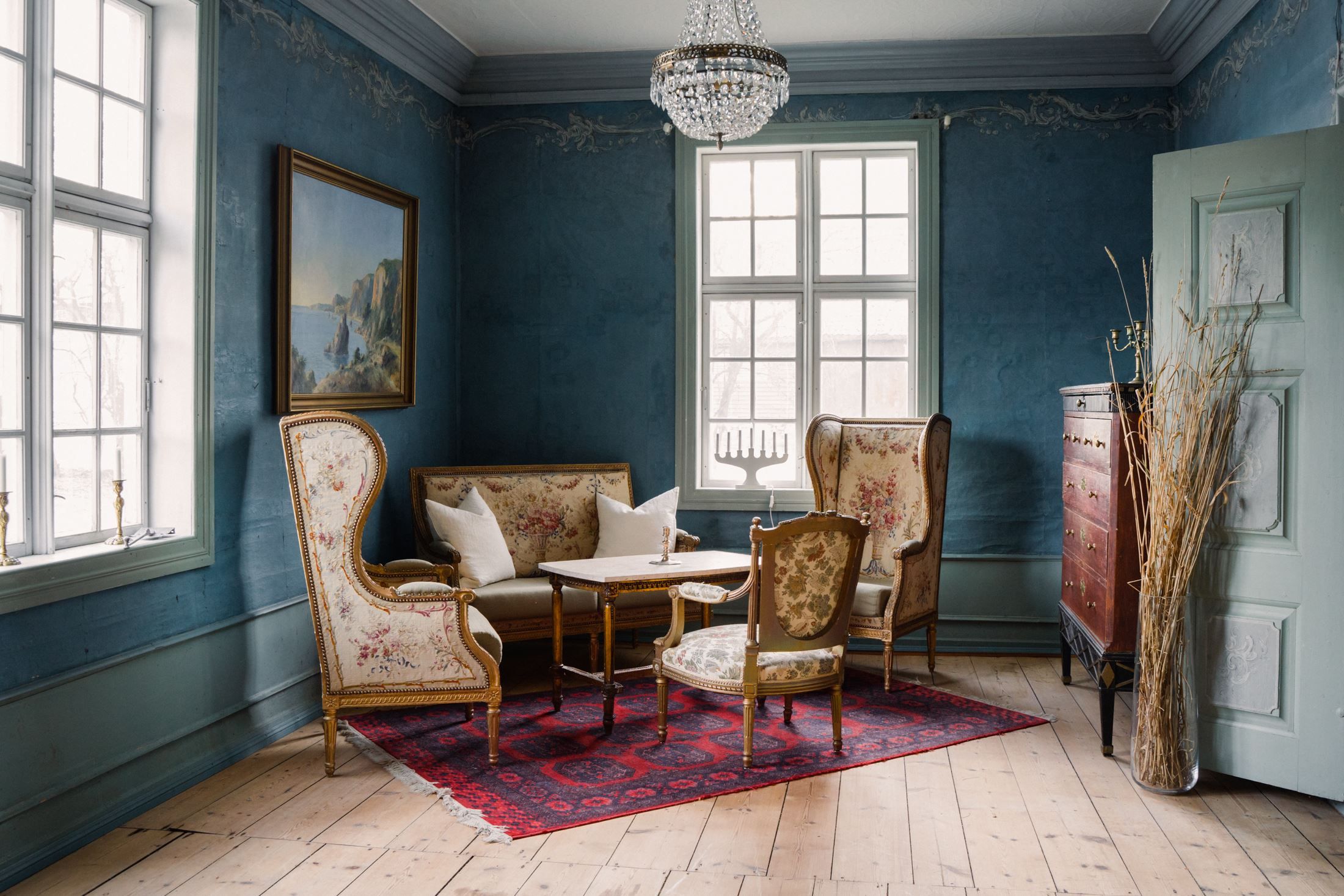 Blue salon at Skrivergaarden with classic furniture, artwork and historic details.