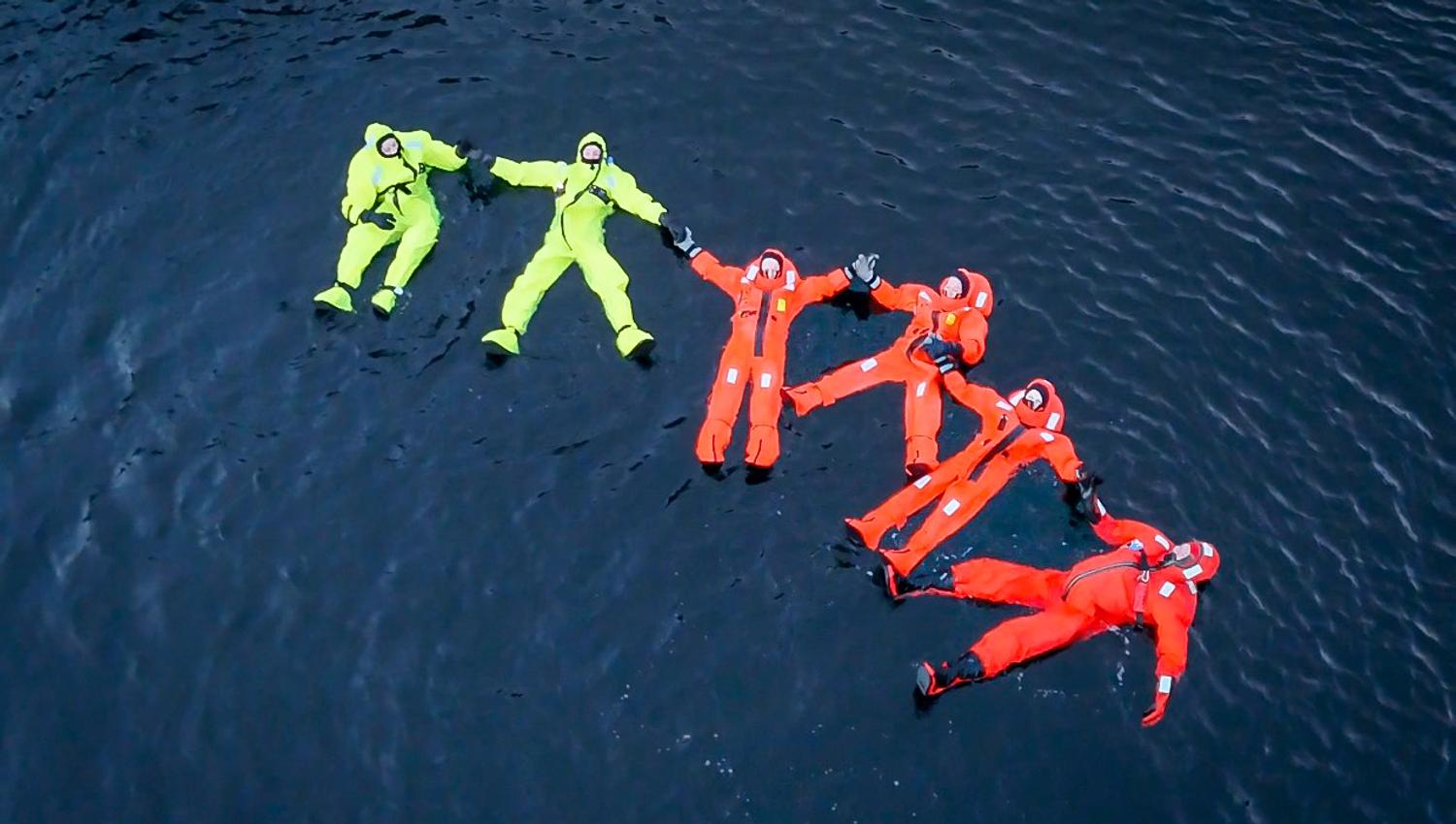 People floating in the Hardangerfjord in immersion suits