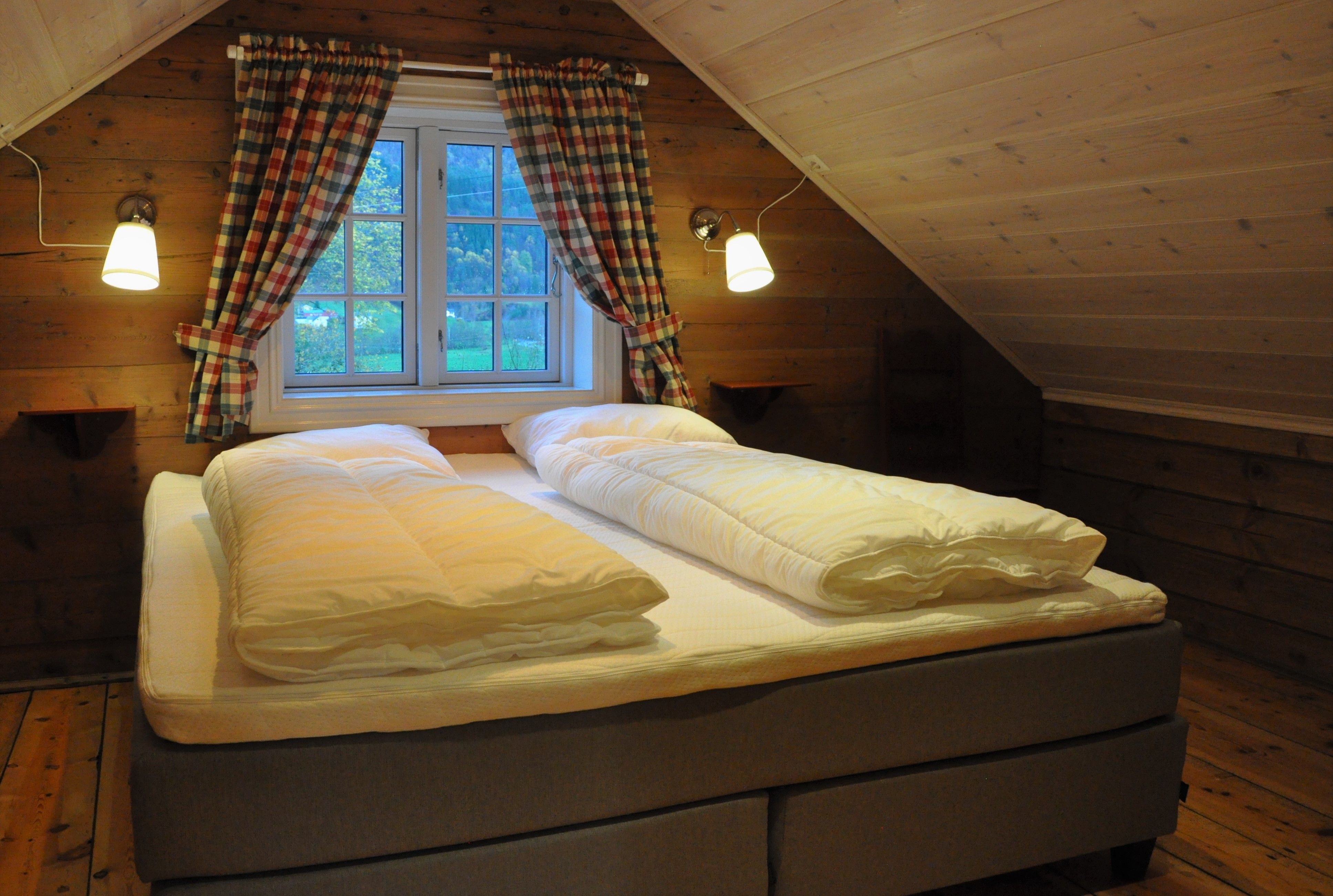 A king size bed with windows behind it