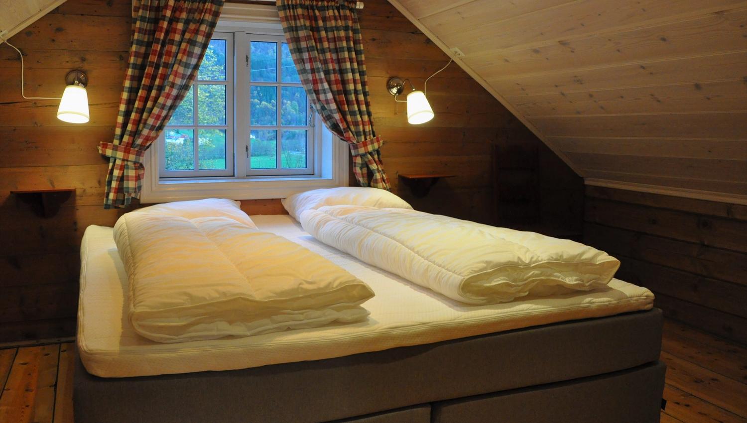 A king size bed with windows behind it