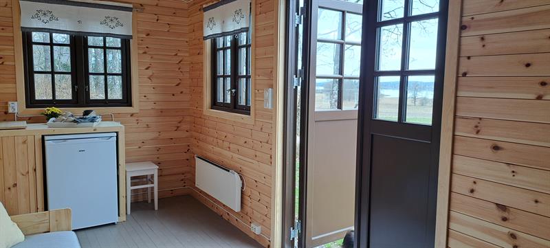 Interior of Gjeterhytta with kitchenette, refrigerator and entrance door