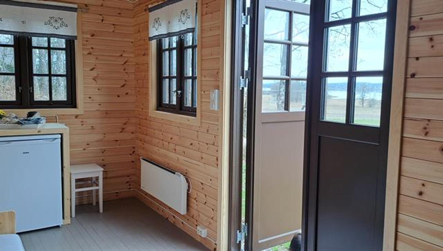 Interior of Gjeterhytta with kitchenette, refrigerator and entrance door