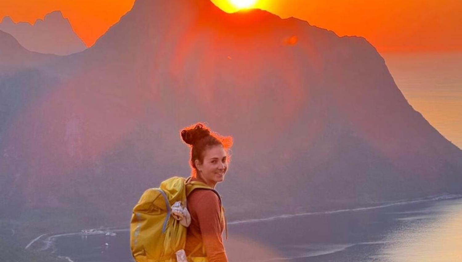 A guest looks out on the midnight sun over the mountain