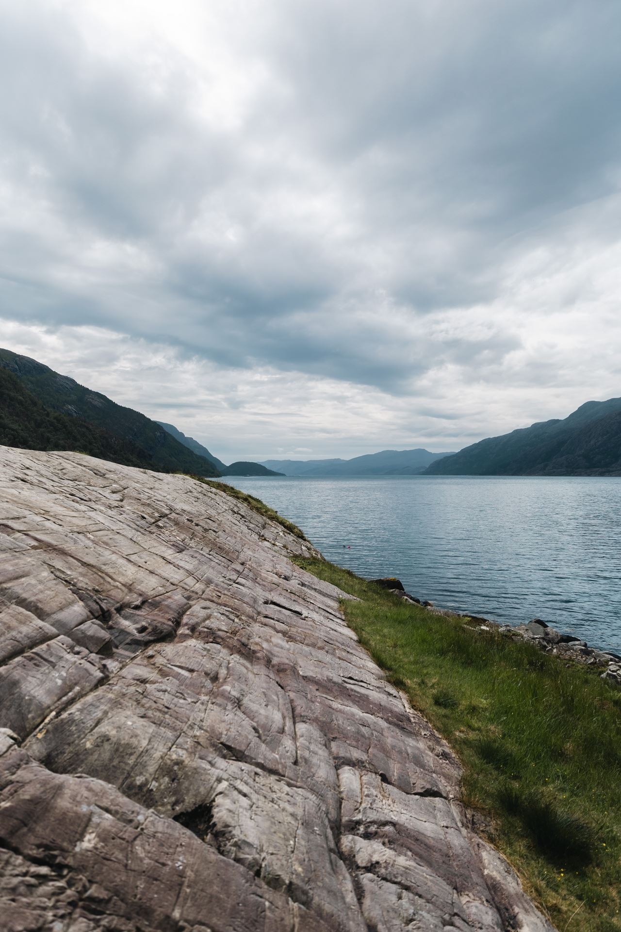 The fjord landscape surrounding Vingen, with ancient rock carvings on the rock surface in the foreground.
