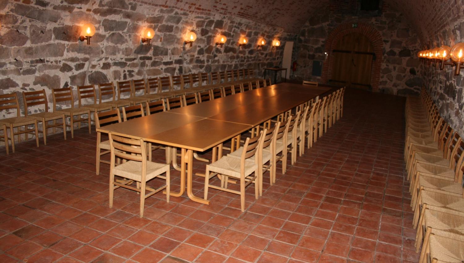Inne i selskapslokalet Fredrik IIIs hall - langbord og stolrader i hvelvet lokale