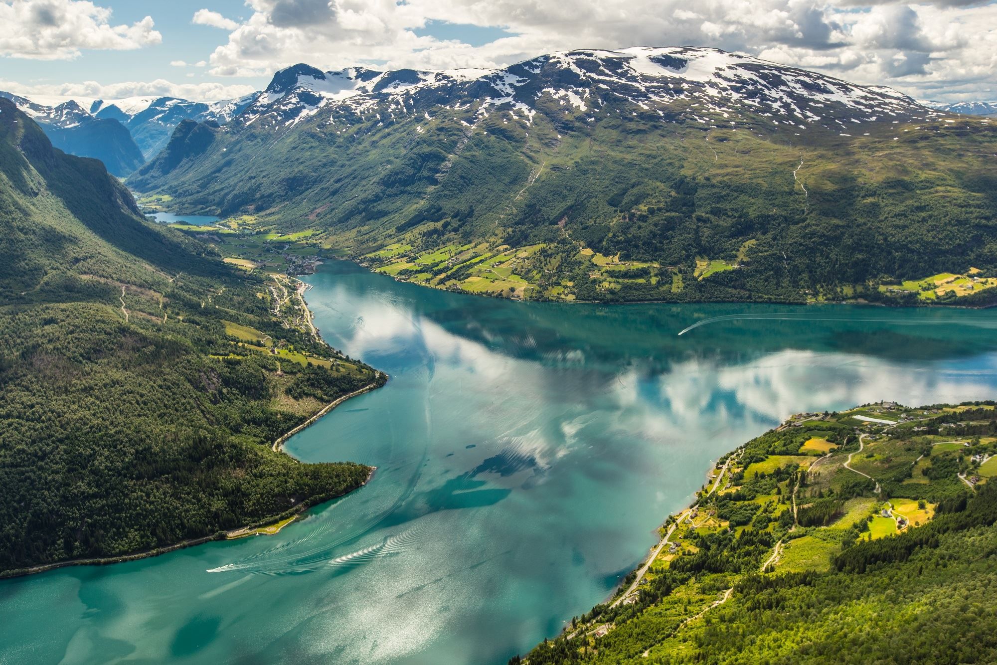 Turquoise mountain lake surrounded by green slopes and rugged mountains near Hoven.