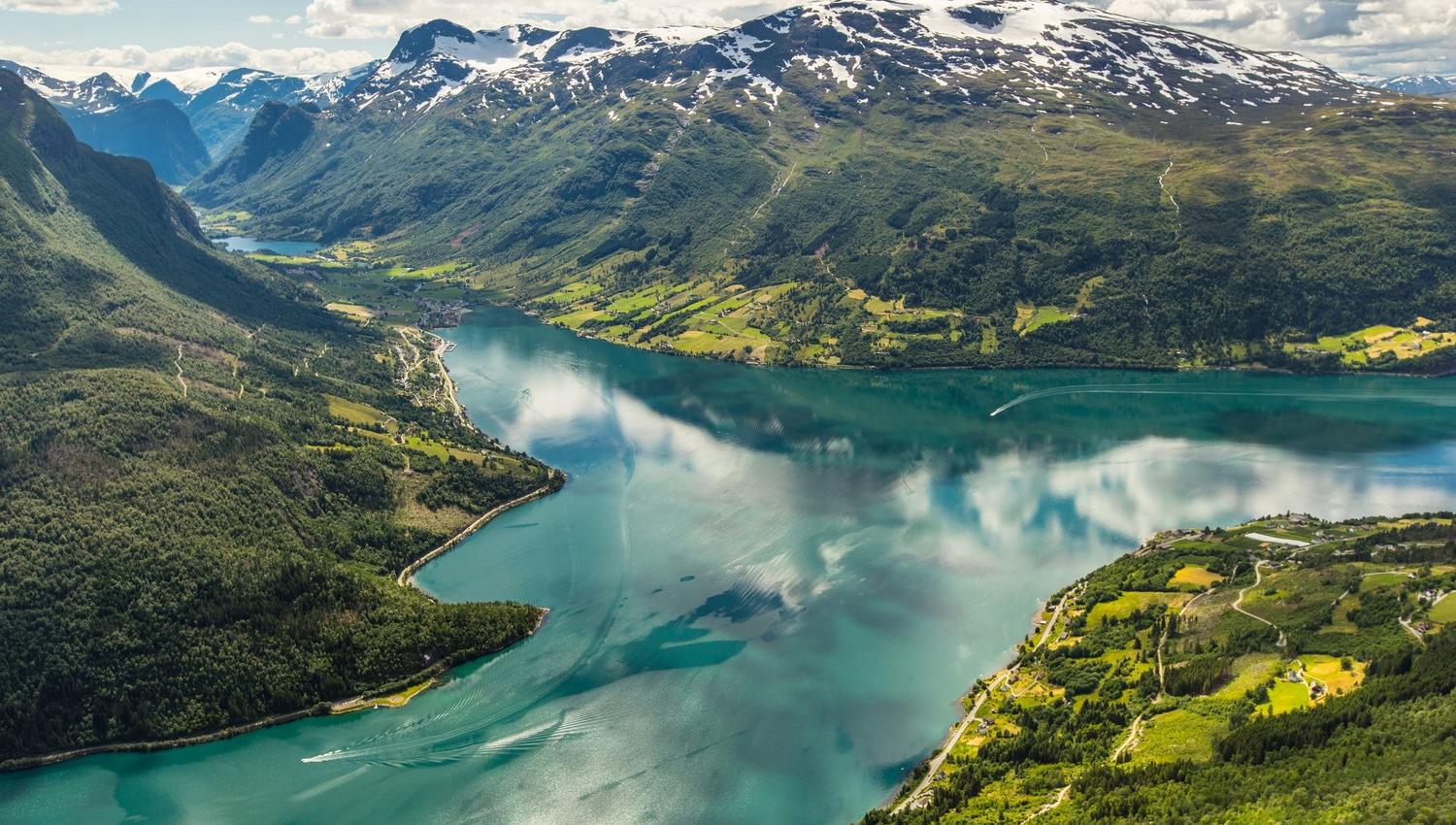 Turquoise mountain lake surrounded by green slopes and rugged mountains near Hoven.