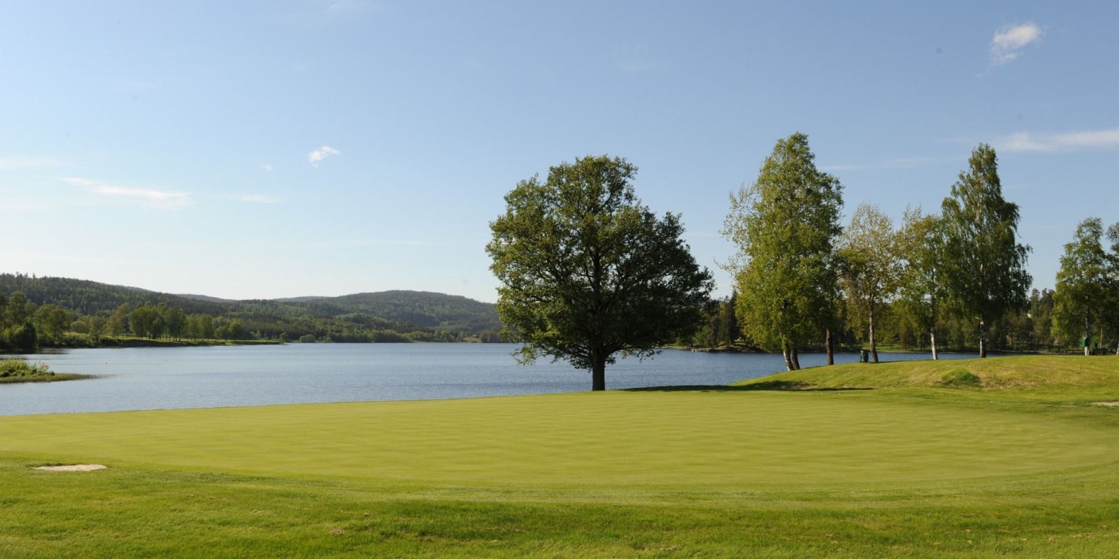 view of the golf course with the fjord in the background
