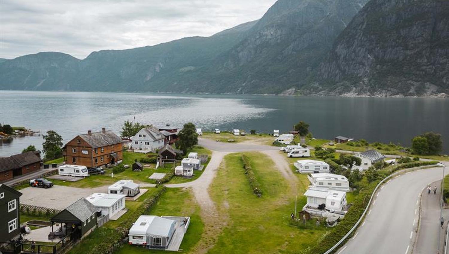A drone photo og the campground with the fjord and mountains in the background