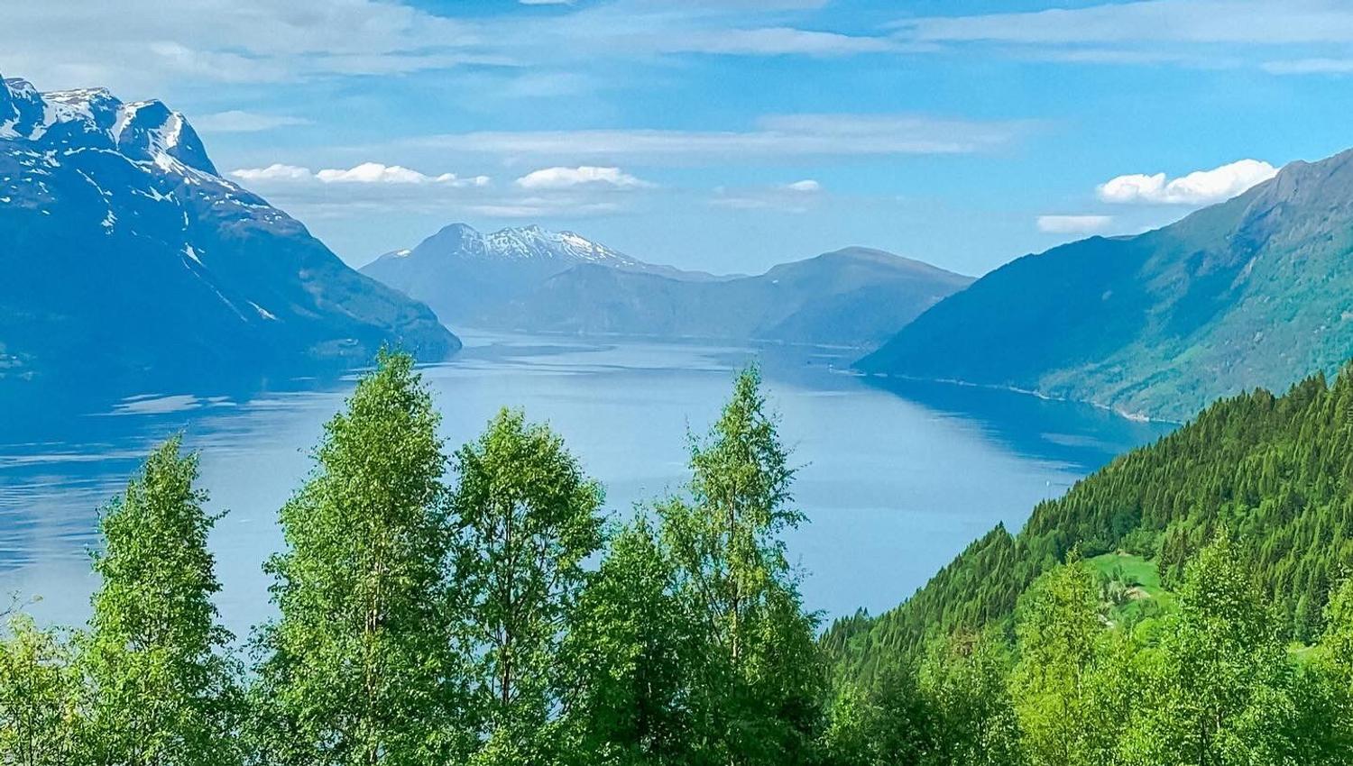 Stunning panoramic view from the Birdbox cabin at Skaara Living on Lotsberg in Nordfjord, surrounded by mountains and fjord landscape.
