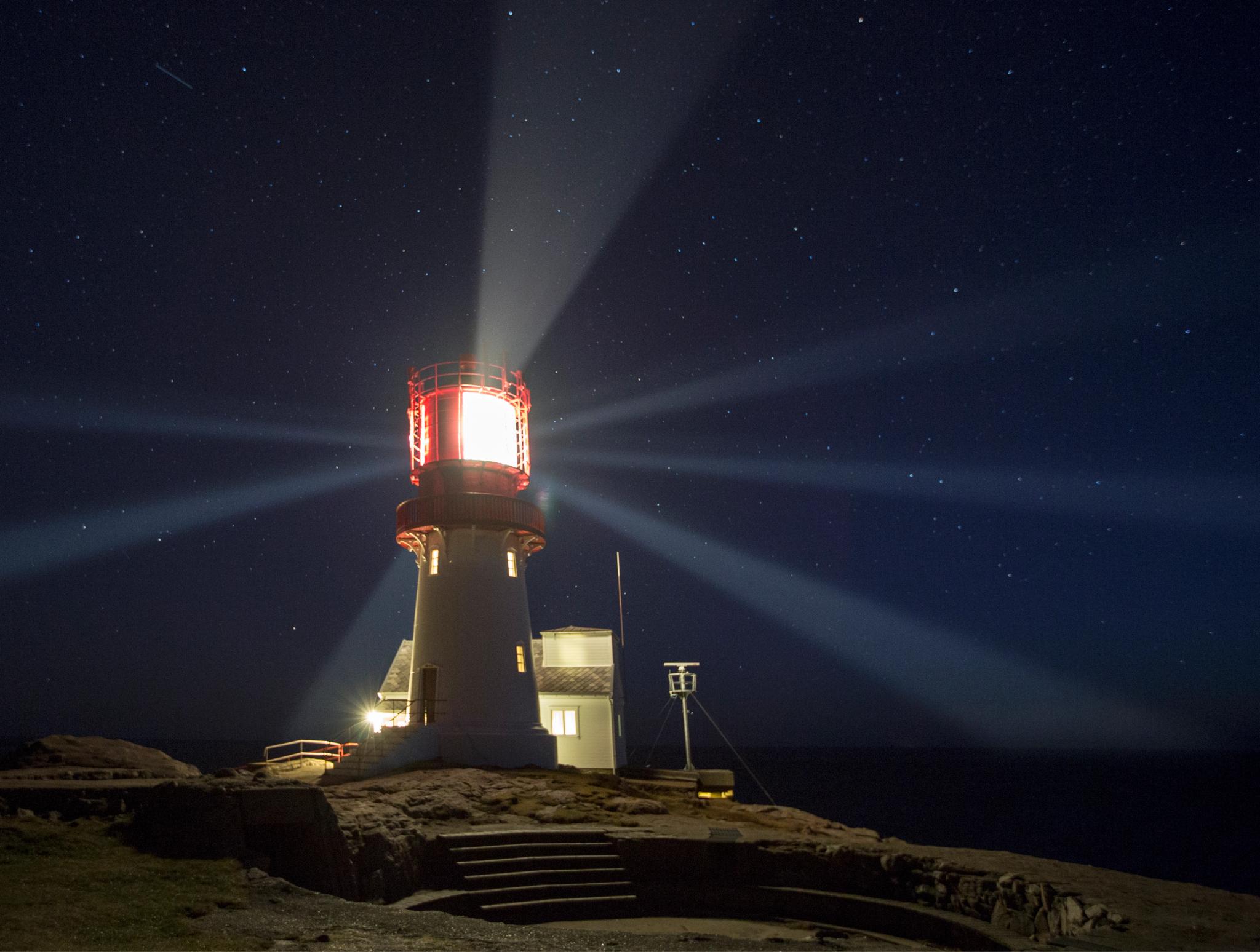 Lindesnes lighthouse with the lantern lit at night.