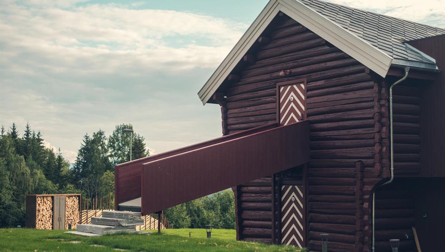 Traditional stabbur suite surrounded by green countryside.