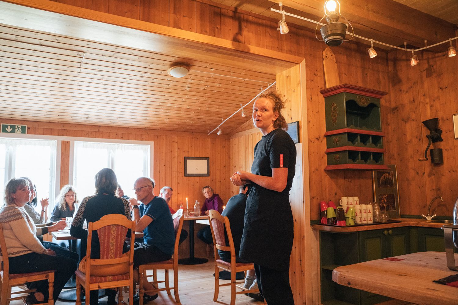 A server talking to the guests in the dining room.