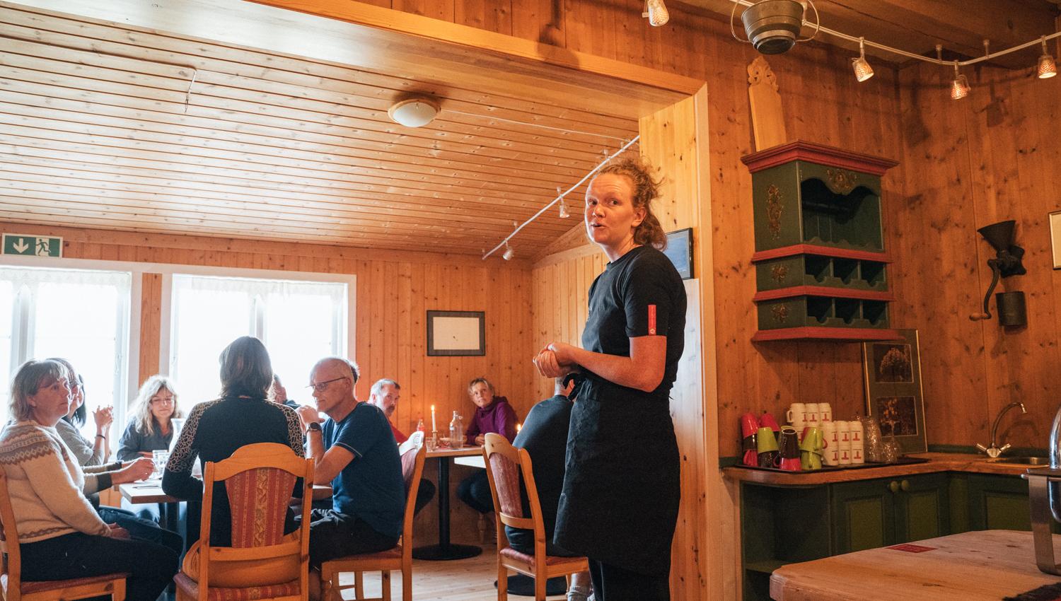 A server talking to the guests in the dining room.