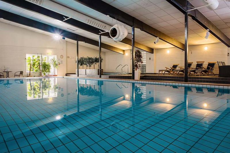 Innendørs svømmebasseng i spaavdelingen på Hankø Hotell & Spa, med solsenger langs bassengkanten.
