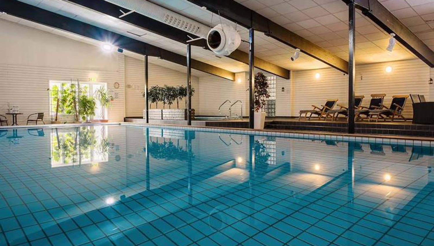Innendørs svømmebasseng i spaavdelingen på Hankø Hotell & Spa, med solsenger langs bassengkanten.