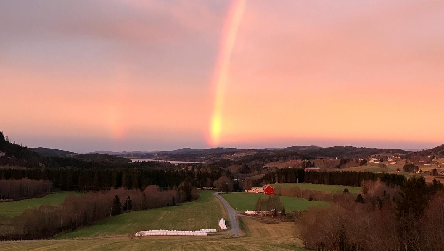 Troset i Levanger Kommune: Utsikt fra gården med regnbue og solnedgang