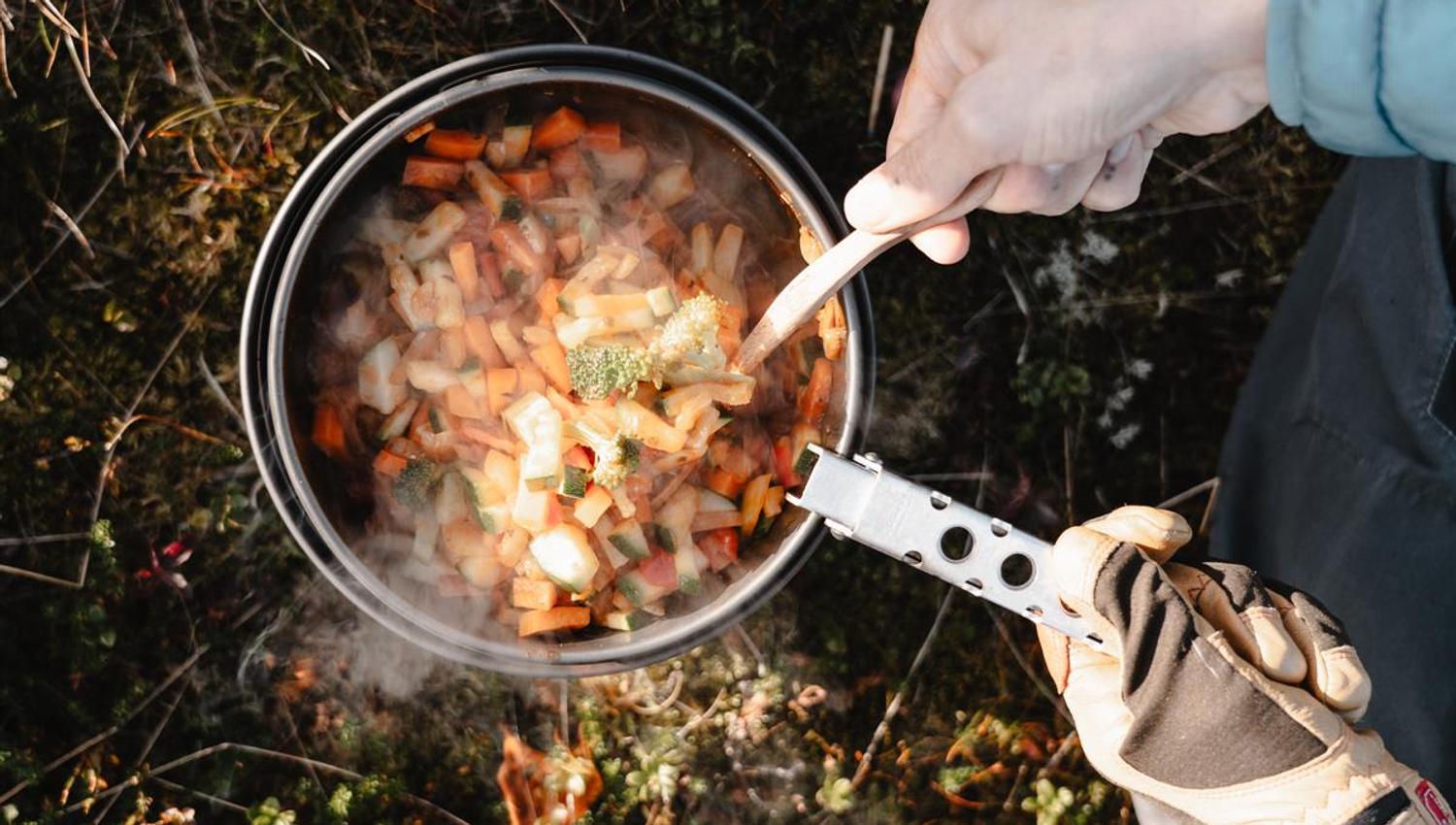 Pot with food over a fire in the forest.