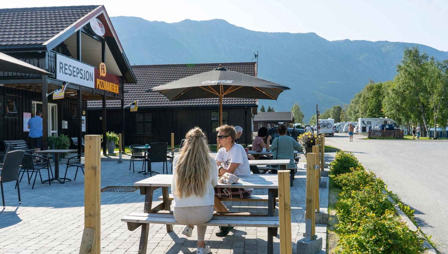 Reisende på uteserveringen til Topcamp Mosjøen