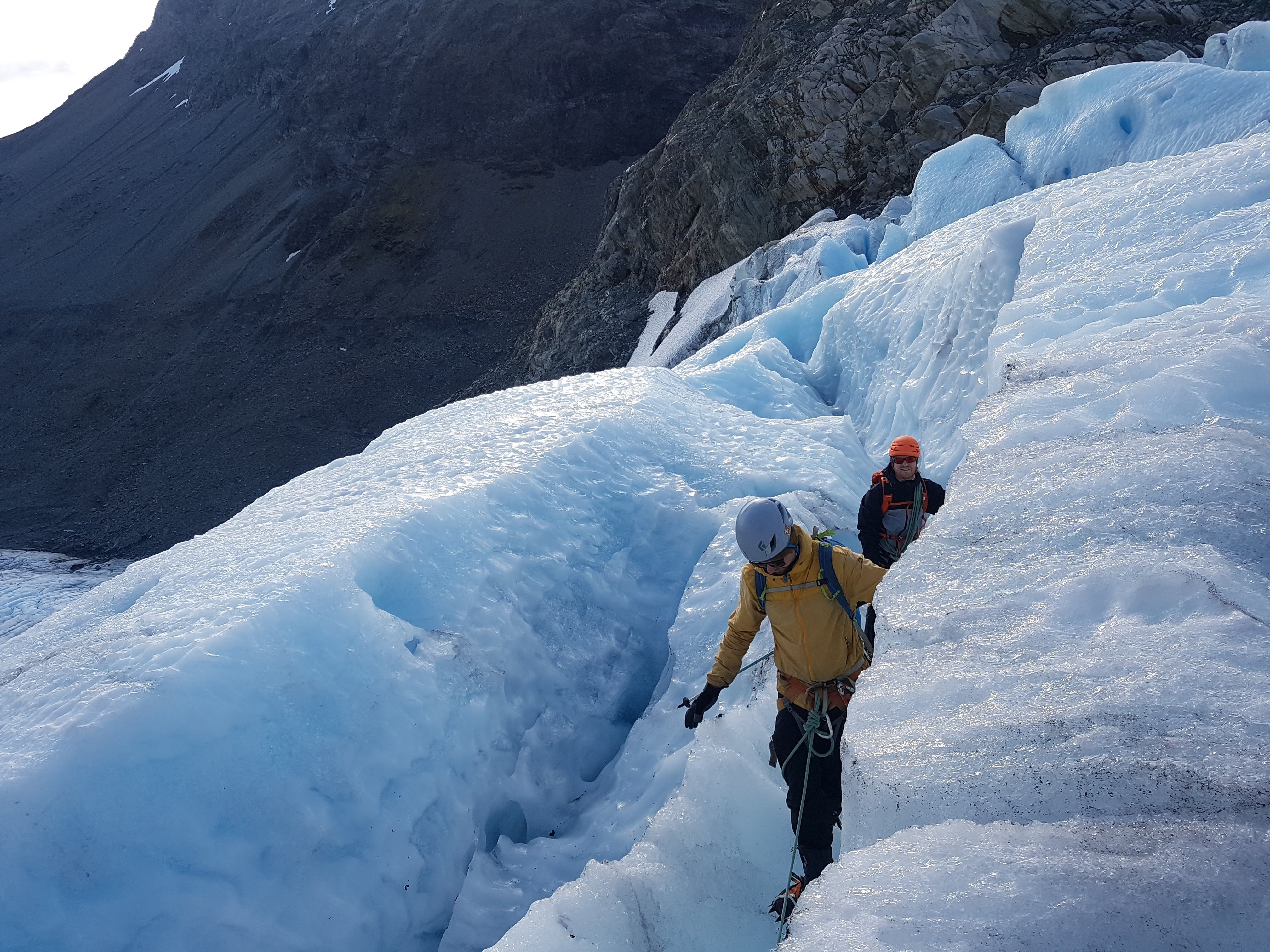 Two persons walking on a glacier.