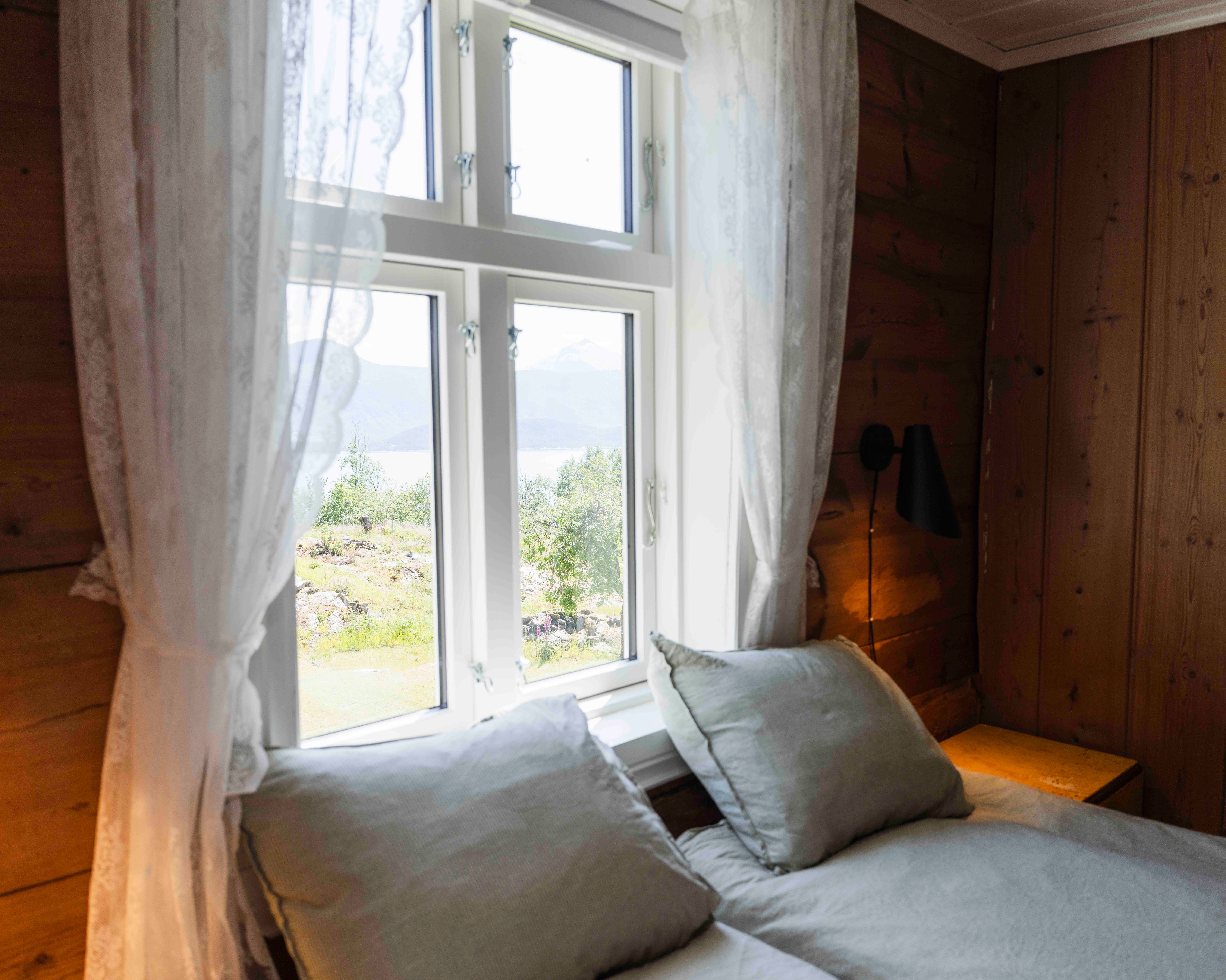 Bedroom with fjord views and soft morning light at Stigen Fjordlodge in Hardanger.