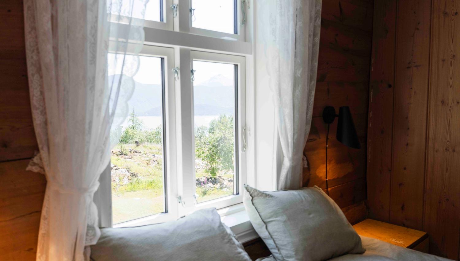Bedroom with fjord views and soft morning light at Stigen Fjordlodge in Hardanger.