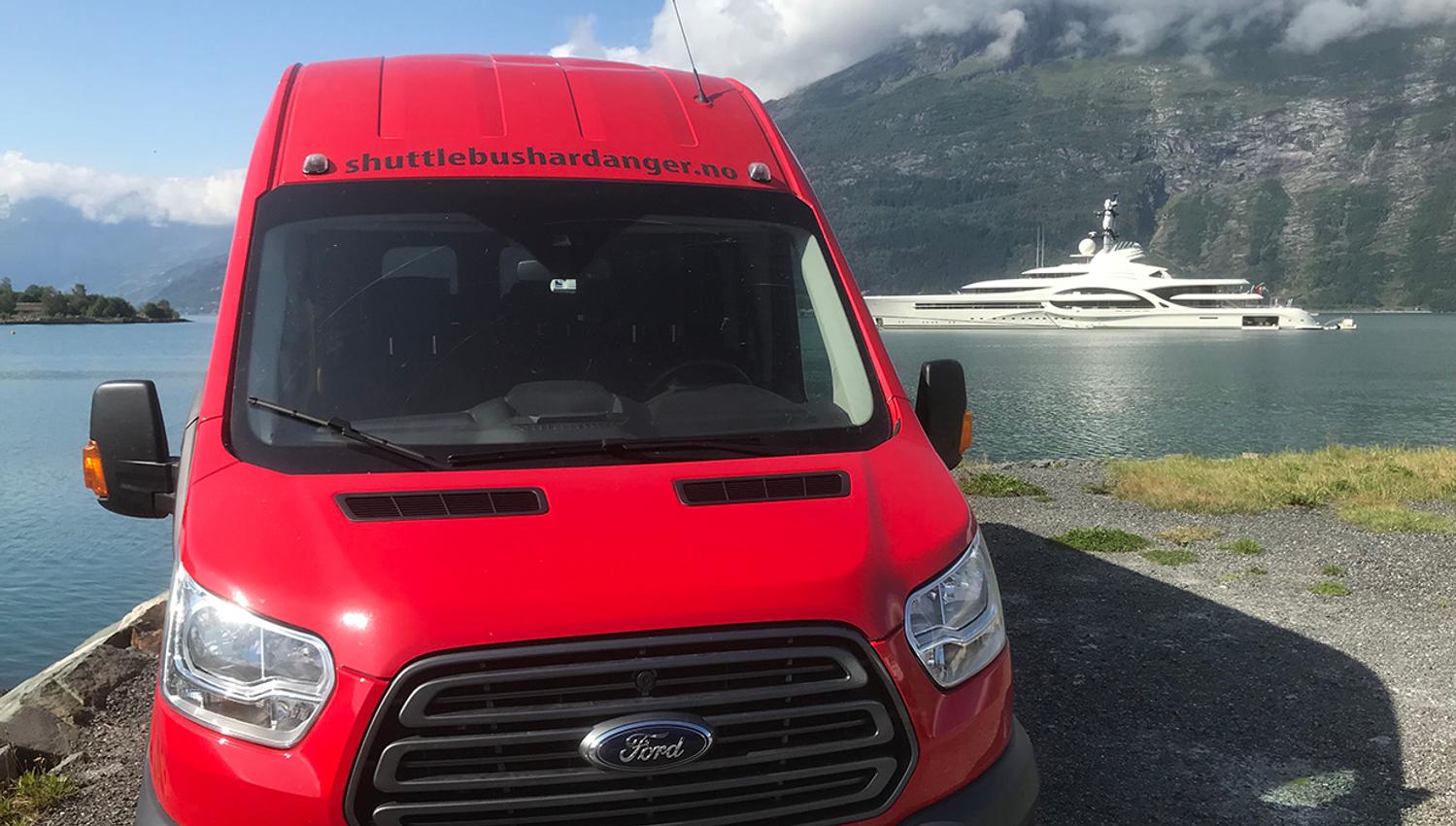 Shuttle bus with the Hardangerfjord in the background.