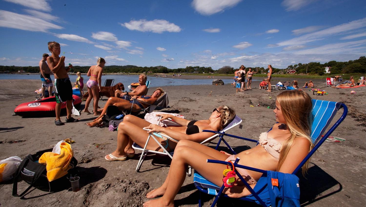 Folk soler seg på stranda