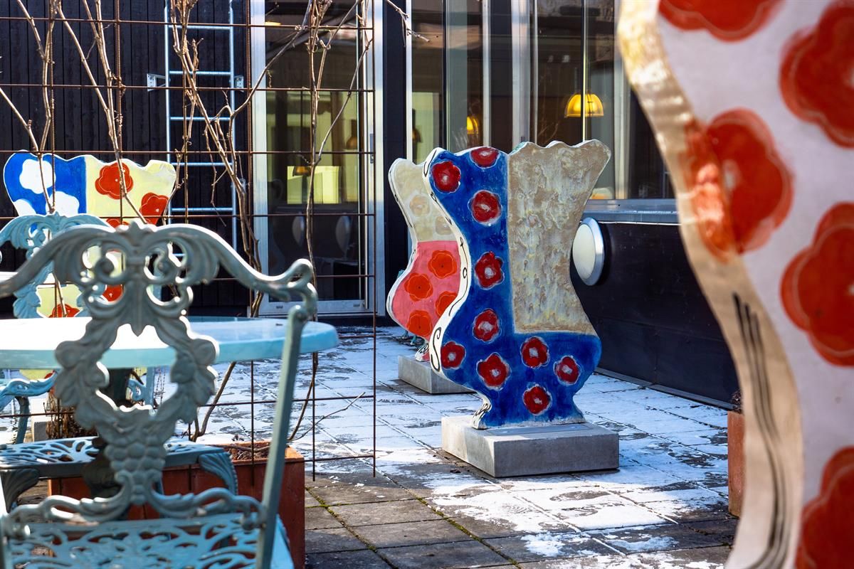 Colorful outdoor sculptures arranged in a courtyard next to a building.