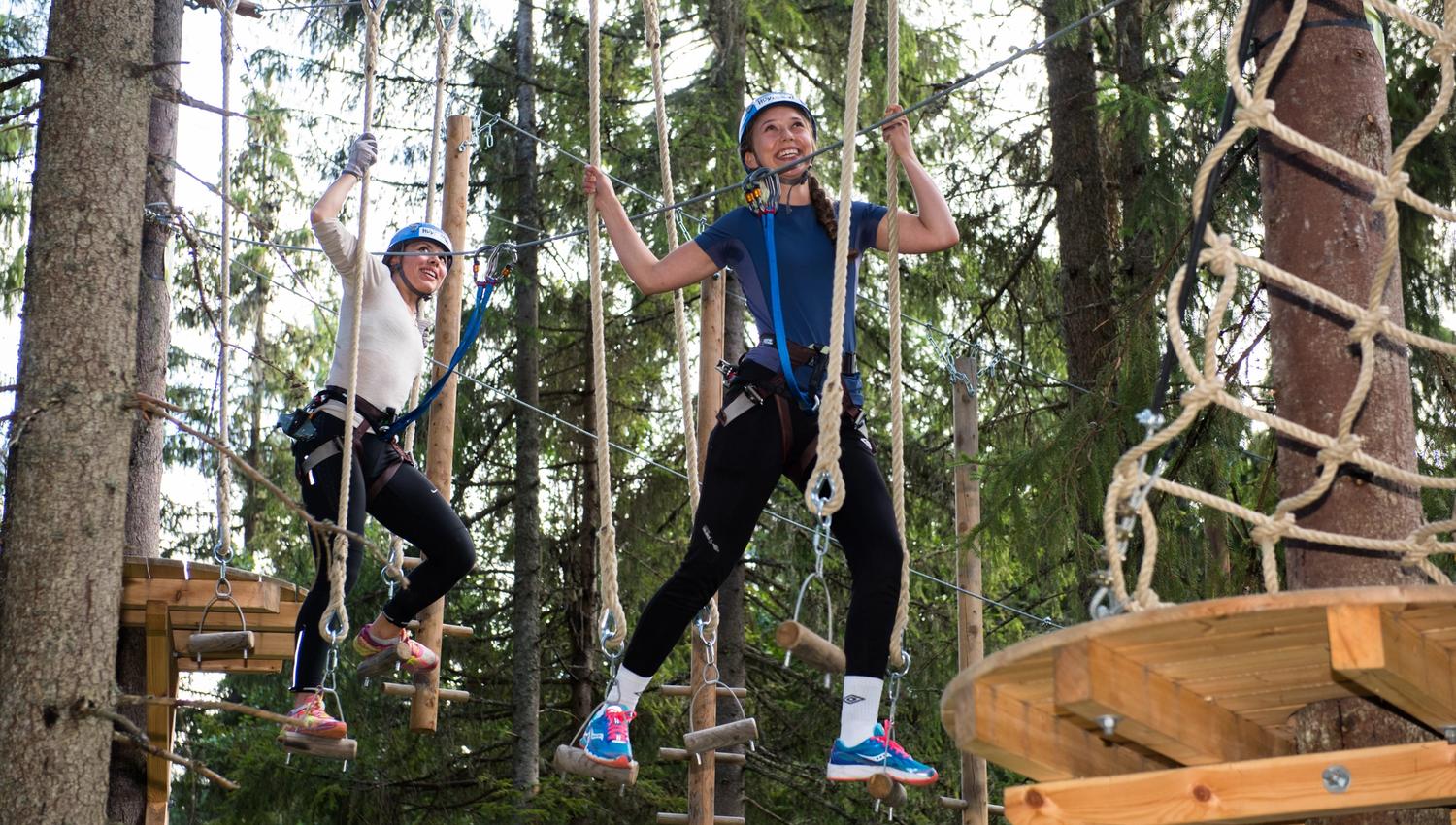 Girls in an clombing park - balancing with ropes