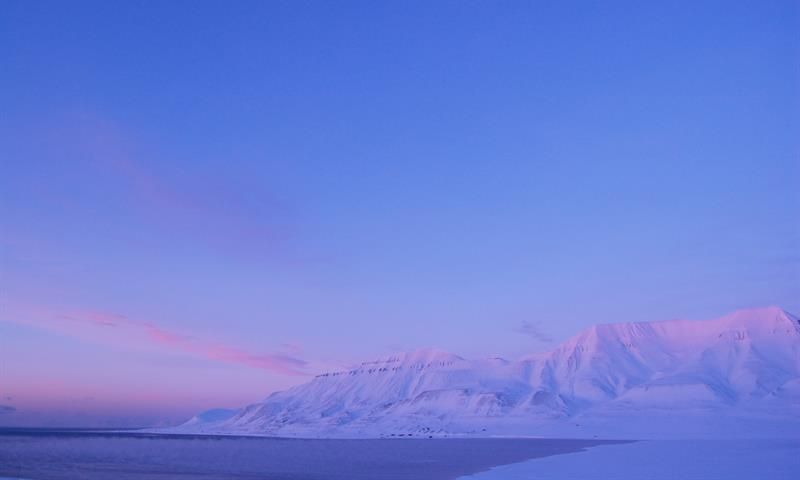 Hiorthhamn seen in the distance, in blue and pink pastel colours 