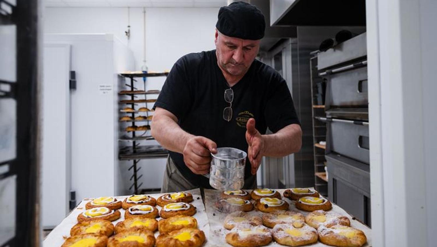 Baker decorating sweet buns.