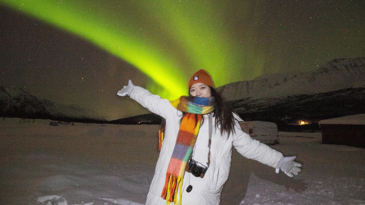 A guest standing under the Northern Lights