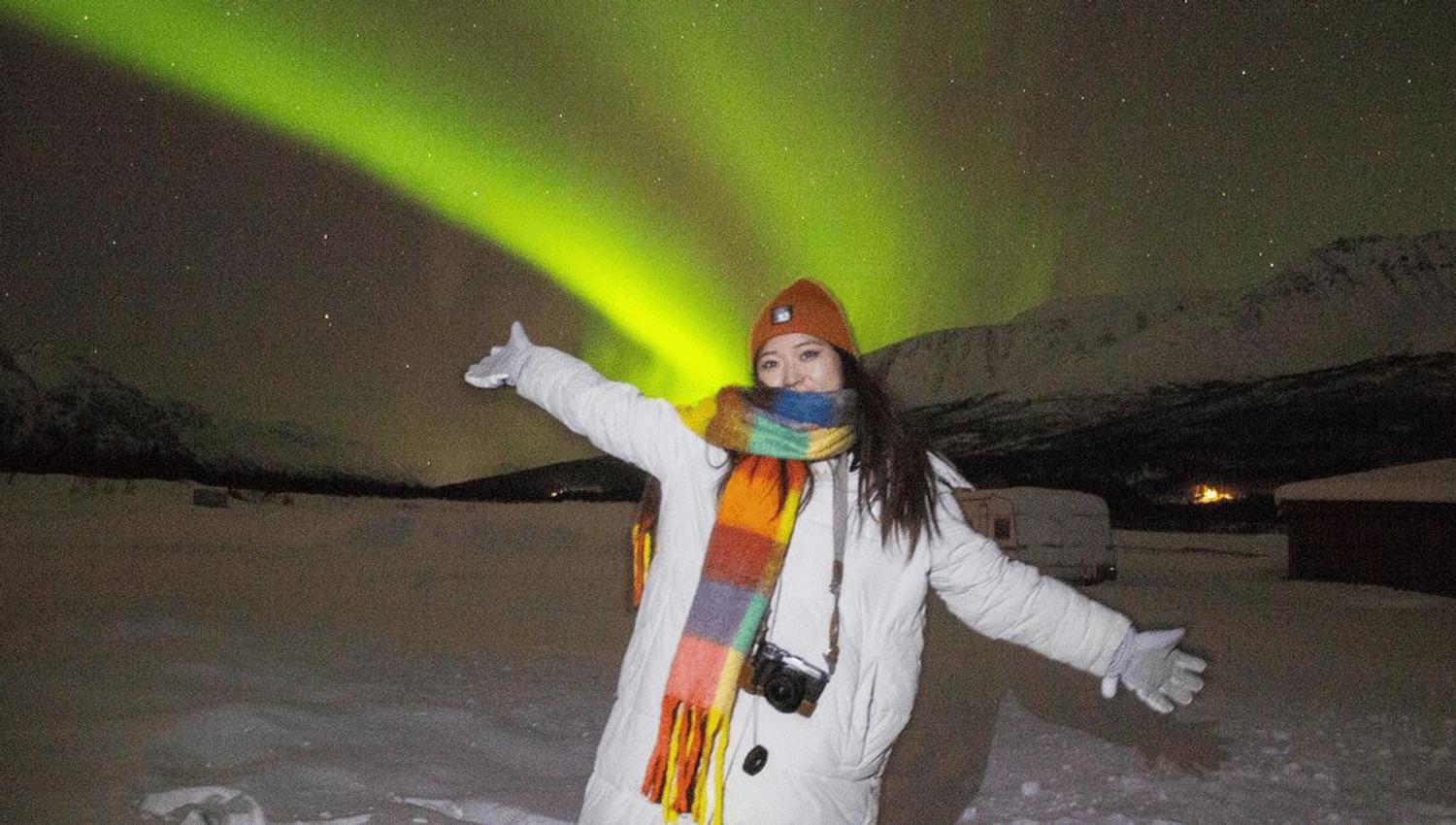 A guest standing under the Northern Lights