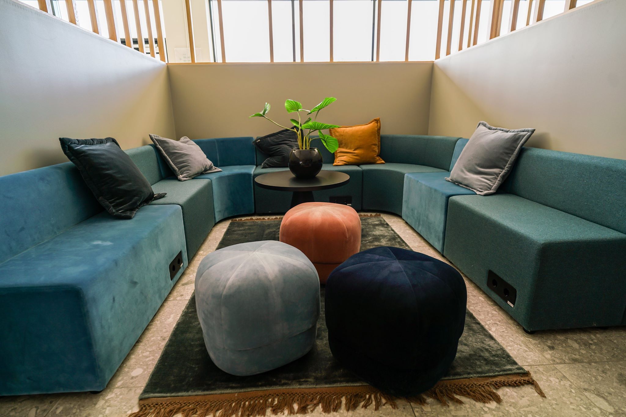 Relaxing seating area with a blue sofa and colorful poufs, ideal for unwinding.